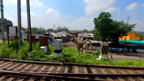 cityscape-view-from-a-moving-train-|-Small-city-near-a-river-and-road-near-a-railway-tracks-video-background-in-4K