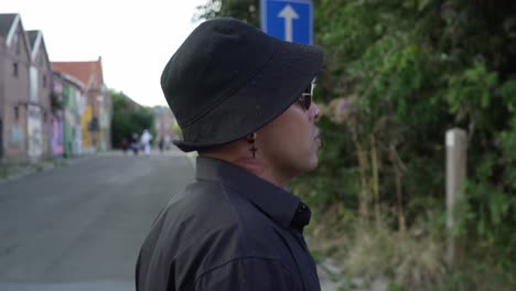 Hispanic-guy-walking-through-abandoned-town-in-Belgium