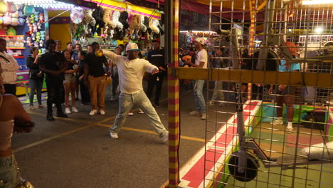 Eine-Menge-Sieht-Zu,-Wie-Ein-Mann-An-Einem-Sommerabend-An-Der-Cne-Einen-Ball-Bei-Einem-Karnevalsspiel-Wirft