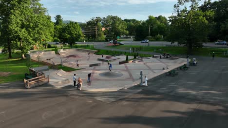 Grupo-De-Personas,-Adultos-Jóvenes-Se-Reúnen-Para-Patinar-Y-Disfrutar-Del-Parque-Al-Aire-Libre