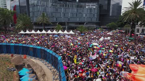 Vista-Aérea-Baja-Sobre-La-Gente-Del-Arco-Iris-En-El-Desfile-Del-Orgullo-Gay-En-La-Soleada-Ciudad-De-México---Reversa,-Inclinación,-Disparo-De-Drones