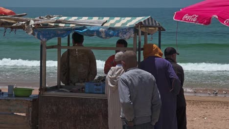 Pescadores-Alrededor-De-Un-Puesto-De-Pesca-En-La-Playa-De-Taghazout