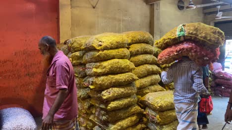 Worker-carrying-sacks-in-head-at-a-wholesale-shop