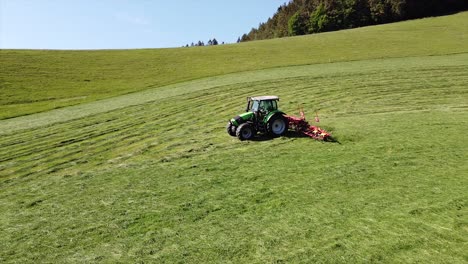 Aerial-Tractor,-agricultural-machine-making-hay,-driving-over-field