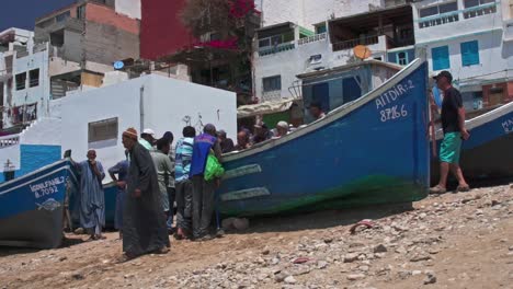 Pescadores-Reunidos-Alrededor-De-La-Pesca-Del-Día-En-La-Playa-De-Taghazout