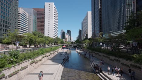 Parque-Del-Arroyo-Cheonggyecheon-Con-Multitud-De-Personas-Relajándose-En-Un-Hermoso-Día-De-Verano-En-La-Ciudad-De-Seúl,-Corea-Del-Sur