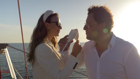 Couple-clinking-their-champaign-glasses-the-classic-way-on-a-sailing-boat