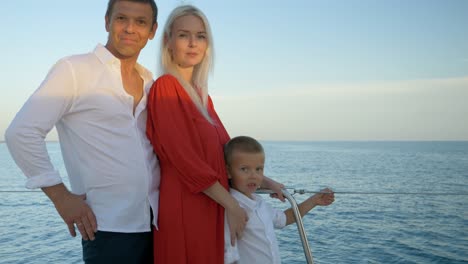 Happy-family-portrait-with-father,-mother,-and-their-son-on-a-sail-boat