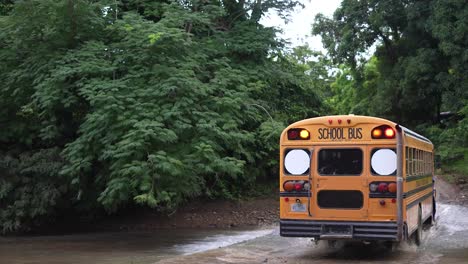 student-bus-passing-over-river,-poor-village,-rivas-streets,-nicaragua,-colonial-town,-poor-houses,-nicaraguanse