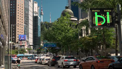 Coches-Con-Mucho-Tráfico-En-El-Casco-Antiguo-Del-Centro-De-Seúl-Con-Vistas-A-La-Torre-Namsan-Detrás-De-Los-Edificios