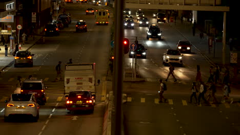 Fußgänger-überqueren-In-Hongkong-Eine-Straße,-Während-Autos-Und-Busse-An-Der-Ampel-Warten