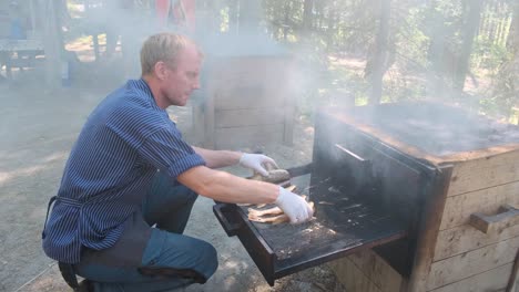 Hombre-Noruego-Haciendo-Un-Pescado-Caliente-Humeante,-En-Un-Bosque-En-La-Ciudad-De-Elverum-En-Noruega-El-15-08-2022