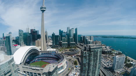 Lapso-De-Tiempo-De-Movimiento-Sobre-Puntos-De-Referencia-Frente-Al-Mar-En-El-Centro-De-Toronto-Durante-El-Día-Con-Vista-De-La-Torre-Cn-Y-El-Techo-Retráctil-Del-Centro-De-Rogers-En-Movimiento