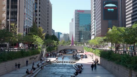 Ambiente-De-La-Ciudad-De-Seúl-En-El-Parque-Del-Arroyo-Cheonggyecheon---Gente-Relajándose-En-Un-Día-De-Verano-En-El-Centro,-Corea-Del-Sur