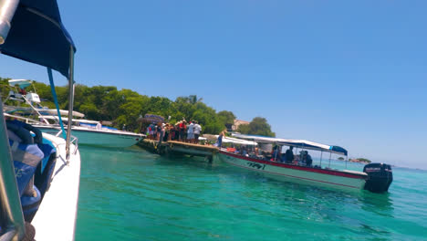 Allgemeine-Aufnahme-Eines-Schnellboots,-Das-Am-überfüllten-Dock-Des-Ozeanariums-Ankommt,-Während-Viele-Touristen-An-Einem-Sonnigen-Tag-Auf-Ihr-Schnellboot-Warten