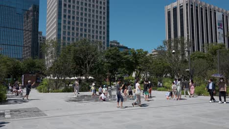 Familias-Coreanas-Con-Niños-Pasando-Un-Buen-Rato-Jugando-Cerca-De-La-Fuente-En-El-Renovado-Parque-Gwanghwamun-Plaza-En-Seúl