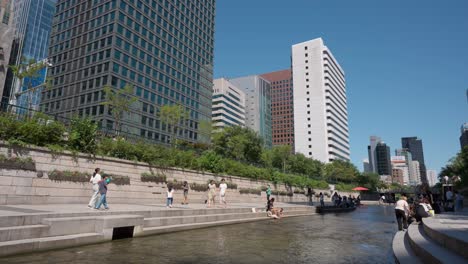 Gente-Coreana-Caminando-Por-El-Arroyo-Cheonggyecheon-Relajándose-En-Un-Día-Soleado-De-Verano-En-La-Ciudad-De-Seúl,-Corea-Del-Sur