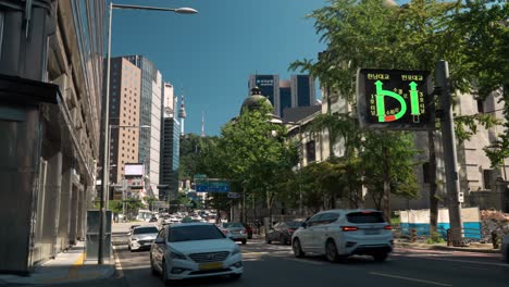 Seoul-Busy-Sogong-ro-street-with-Cars-traffic-and-view-of-N-Seoul-Tower,-pov-from-a-sidewalk