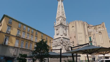 Tourists-Walking-Past-Obelisk-Guglia-of-the-Immaculate-Virgin-on-Piazza-Gesu-Nuovo-in-Naples-Napoli,-Italy