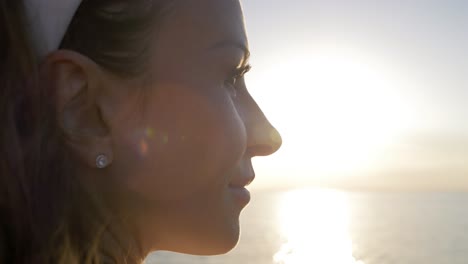 Woman-enjoying-the-sunset-at-sea-on-a-sailboat-