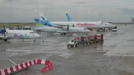 Velana-International-Airport-In-Male-An-Einem-Geschäftigen-Bewölkten-Tag-Mit-Bussen-Und-Flugzeugen,-Die-Draußen-Geparkt-Sind