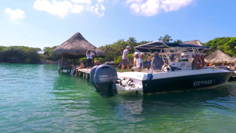 Allgemeine-Aufnahme-Eines-Schnellboots-Im-Ozean,-Das-An-Einem-Sonnigen-Tag-An-Einem-überfüllten-Privaten-Inseldock-In-Cartagena-Kolumbien-Ankommt