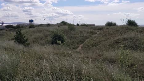 Dunas-De-Arena-En-La-Bahía-De-Swansea-Con-Turbinas-De-Viento-En-El-Fondo-Uk-4k