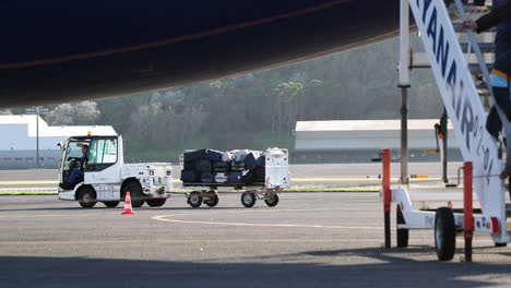 Man-Driving-Baggae-Tug-With-Cart-Carrying-Luggages-Of-Passengers-Arrived-At-Lajes-Airport-In-Terceira-Island,-Azores,-Portugal