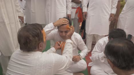 A-group-of-Indian-priest-applies-holy-tilak-made-with-sandalwood-on-the-forehead-of-people-during-Ram-Rath-procession-on-the-occasion-of-yearly-celebration-of-Ram-Navmi