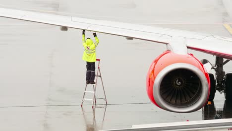 An-employee-of-the-ground-service-of-the-airport-operating-the-tanker-refills-the-aircraft-with-aviation-fuel-on-rainy-days-in-Bangkok