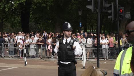 Un-Oficial-De-Policía-Observa-Cómo-Miles-De-Dolientes-Se-Alinean-En-Las-Calles-Fuera-Del-Palacio-De-Buckingham-Para-Presentar-Sus-Respetos-Después-Del-Fallecimiento-De-La-Reina-Elizabeth,-Londres,-Inglaterra