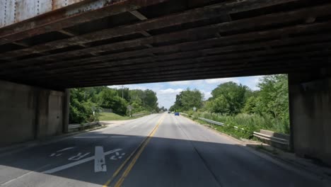 Punto-De-Vista:-Conducción-De-Camiones-Debajo-Del-Puente-Con-Un-Tren-De-Carga-Que-Pasa-Sobre-Los-Rieles-Sobre-La-Carretera