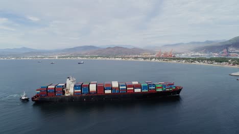 Vista-Aérea-Siguiendo-Un-Gran-Buque-De-Carga,-Moviéndose-Hacia-El-Puerto-De-Manzanillo,-En-México