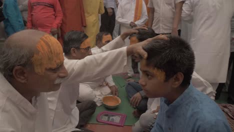 A-group-of-Indian-priest-applies-holy-tilak-made-with-sandalwood-on-the-forehead-of-people-during-Ram-Rath-procession-on-the-occasion-of-yearly-celebration-of-Ram-Navmi