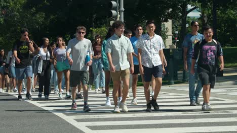 Große-Gruppe-Von-Studenten,-Die-Die-Straße-Im-Zebrastreifen-überqueren