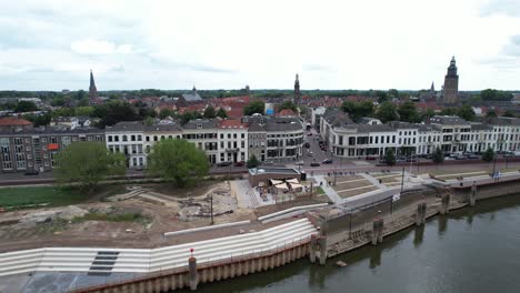 Movimiento-Aéreo-Ascendente-Lateral-Que-Muestra-El-Muelle-En-Construcción-En-El-Río-Ijssel-Con-Trabajos-En-Curso-En-El-Bulevar-Ijsselkade-Del-Desarrollo-Urbano-De-Tower-Town-Zutphen