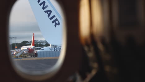 Wing-With-Logo-From-Window-Of-Airplane-View-During-Plane-Takeoff-In-Lisbon,-Portugal---POV