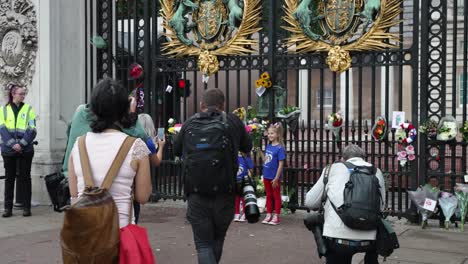 12-De-Septiembre-De-2022:-Madre-Con-Sus-Tres-Hijas-Usando-Una-Camiseta-Azul-Y-Sosteniendo-Un-Ramo-De-Flores-Fuera-De-Las-Puertas-Del-Palacio-De-Buckingham-Para-La-Reina-Elizabeth-Y-La-Prensa-Tomándoles-Fotos