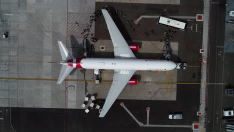 Vista-Aérea-De-Los-Pasajeros-Que-Caminan-Hacia-Un-Avión-En-Una-Terminal-Del-Aeropuerto---De-Arriba-Hacia-Abajo,-Tiro-De-Drones