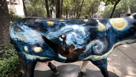 Foto-De-Arte-Callejero-Con-Vacas-Pintadas-En-La-Calle-Que-Representan-Al-ángel-De-La-Independencia