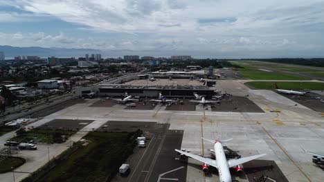 Vista-Aérea-Hacia-Los-Aviones-En-Una-Terminal-Del-Aeropuerto-En-El-Soleado-Puerto-Vallarta,-México