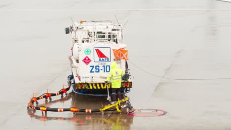 An-employee-of-the-ground-service-of-the-airport-operating-the-tanker-refills-the-aircraft-with-aviation-fuel-on-rainy-days-in-Bangkok