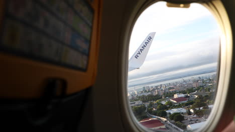 View-Through-Porthole-Of-Ryanair-Boeing-Aircraft-Taking-Off-On-The-Runway-Of-Lisbon-Airport-In-Portugal