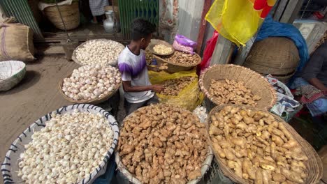 Marktstandhändler-Umgeben-Von-Großen-Körben-Mit-Knoblauch-Und-Ingwer-In-Bangladesch