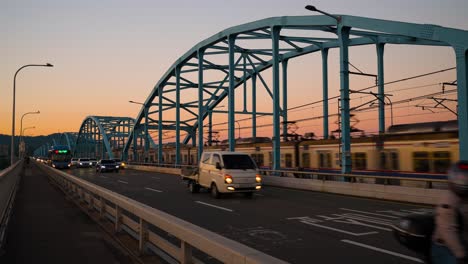 Subway-metro-train-and-cars-traffic-on-Dongjak-bridge-in-Seoul-against-a-colorful-orange-sunset-skyline---real-time,-static