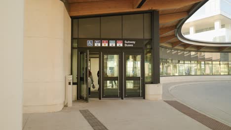 People-exit-and-enter-bus-terminal-at-Vaughan-Metropolitan-Centre-in-Ontario,-Canada