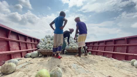 Jornalero-Llevando-Verduras-En-La-Cabeza-Con-Una-Cesta-Desde-Un-Barco-De-Acero-En-Bangladesh