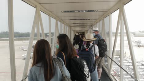 view-inside-the-aeroplane-bridge-while-many-people-boarding-airplane-in-summer-holiday-vacation-time