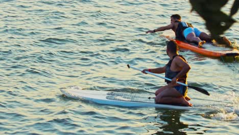 Zwei-Männer,-Die-Während-Der-Goldenen-Stunde-Surfbretter-Im-See-Benutzen