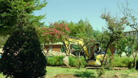 Minibagger,-Der-Im-Sommer-In-Einem-Garten-Oder-Park-Arbeitet---Weitschuss